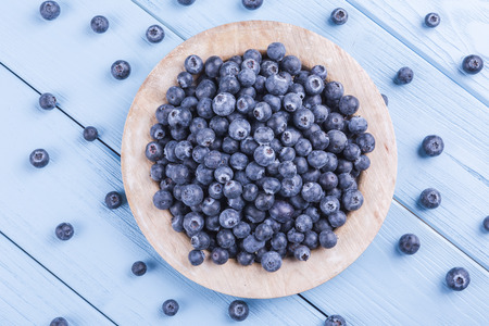 fresh, juicy blueberries on wooden, blue backgroundの写真素材