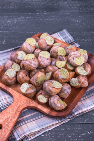 Escargots de Bourgogne on a  plate on wooden Backgroundの写真素材