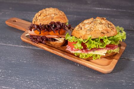 sandwich with salami and salad on wooden backgroundの写真素材