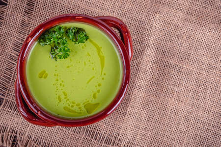Fresh asparagus creamy soup and ingredients on a wooden table.の写真素材