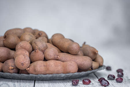 Bowl of fresh tamarinds on wooden table.の写真素材