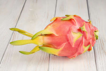 Fresh, pink dragon fruit, pitaya on a white wooden background