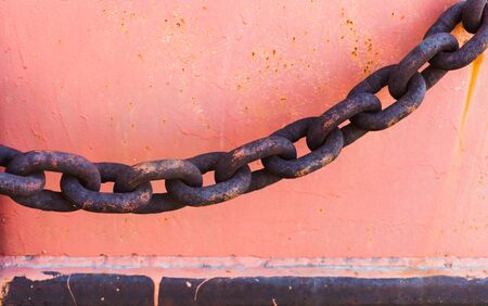 Part of an old rusted chain on a riversideの写真素材