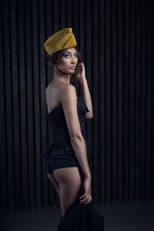 portrait of girl in a sexy black aviator uniform with hatの写真素材