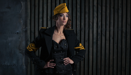 portrait of girl in a sexy black aviator uniform with hatの写真素材