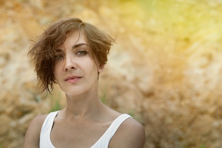Young woman outdoors portrait. Soft sunny colors. in white shirtの写真素材