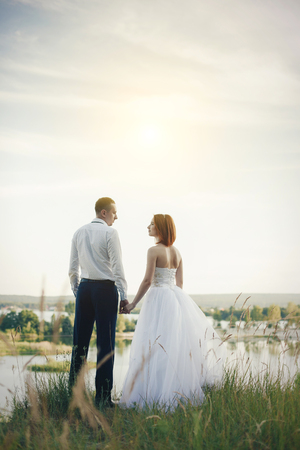 Elegant gentle stylish groom and bride near river. Wedding couple in loveの写真素材
