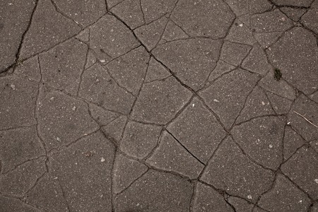 Old road background - surface of grey cracked asphalt texture close upの写真素材