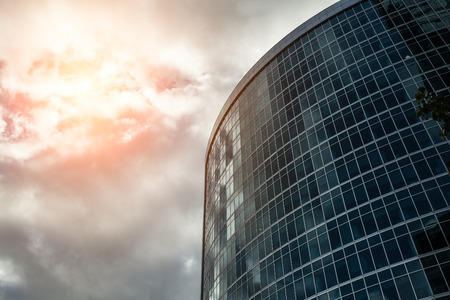 Detail blue glass modern office building background with cloud sky の写真素材
