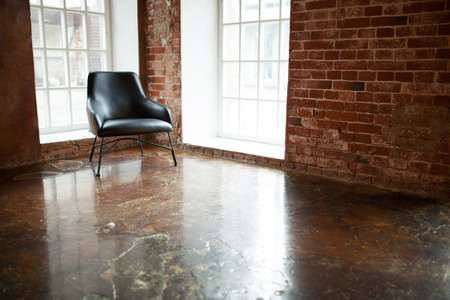 chair stands near a window on the brick wall background in the windows loft styleの写真素材