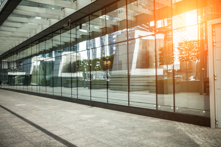 modern city street footpath with glass windows wall and sunlight with nobodyの写真素材