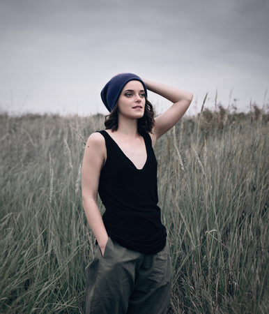 Portrait of romantic girl in black shirt and sport hat in a field autumn lifeの写真素材