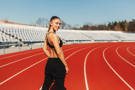 Look Good and feel great. Seen from behind healthy woman jogger in sport style clothes on the stadium in the morning running. Ready to runの写真素材