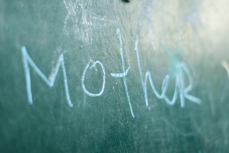 Green Chalkboard close up with wooden frame and the text Motherの写真素材