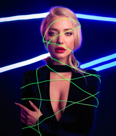 Fashion art photo of elegant model in seductive black swimsuit with light neon colored club spotlights Night club sexy conceptの写真素材