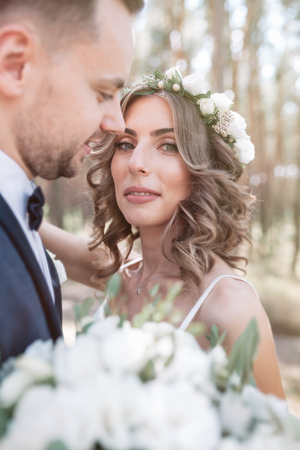 Sunshine portrait of happy bride and groom outdoor in nature location at sunset. Warm summertime.の写真素材