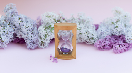 Sand running through the bulbs of an hourglass measuring the passing time in a countdown to a...