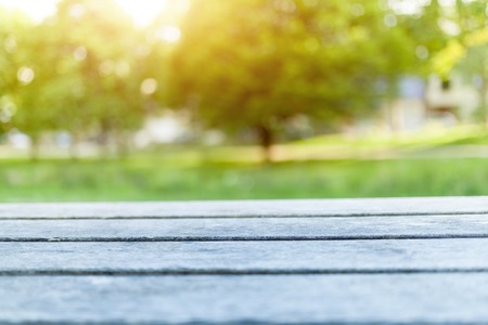 Empty wooden table with blurred city park on background.の写真素材