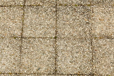 Pebble stone floor tile seamless background. Cement mixed gravel pebble stone floor texture. Wet round pebble stone rock floor in dramatic lightingの写真素材