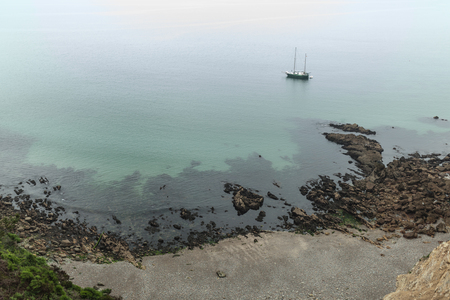 foggy day on the coast with green grass on the rocks Crozon, France 29 May 2018.の写真素材