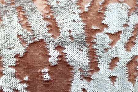 Sequins close-up macro. Abstract background with gold sequins color on the fabric. Texture scales of round sequins with color transition .の写真素材