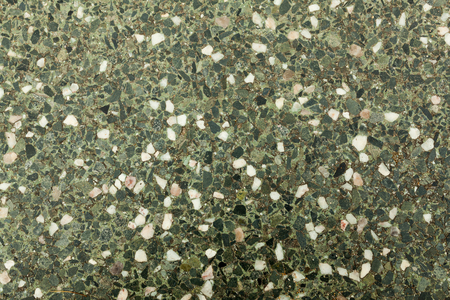 Pebble stone floor tile seamless background. Cement mixed gravel pebble stone floor texture. Wet round pebble stone rock floor in dramatic lightingの写真素材