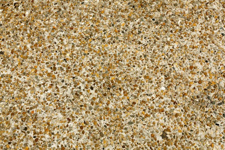 Pebble stone floor tile seamless background. Cement mixed gravel pebble stone floor texture. Wet round pebble stone rock floor in dramatic lightingの写真素材