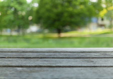 Empty wooden table with blurred city park on background.の写真素材
