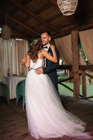 Happy bride and groom and their first dance, wedding in the elegant restaurant with a wonderful light and atmosphere.の写真素材