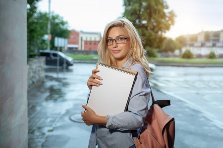 Enthusiastic Happy beautiful young girl smilin gand holding pile of books standing near campus lifestyle positivity academic graduating university school.の写真素材