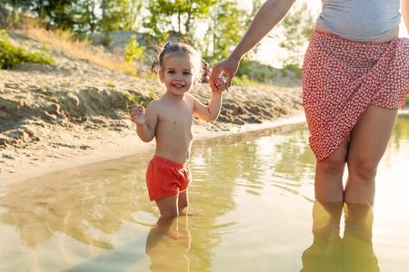Mother and baby on the water. Mom and little child swimming and playing in water. Family summer vacation on exotic island. Travel with kids. Sun protection and swim wearの写真素材