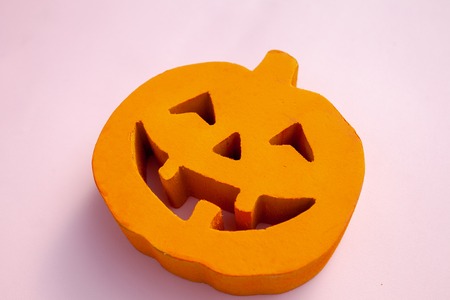 Halloween orange smiling carved pumpkin on a pink backgroundの写真素材