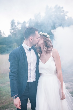 Beautiful bride and groom. Wedding ceremony in nature. Smoke bombsの写真素材