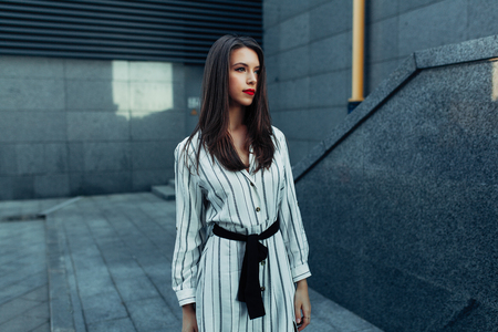 lifestyle fashion portrait of young stylish hipster woman with sunglasses walking on the street, wearing cute trendy outfit enjoy her weekends, travel alone.の写真素材
