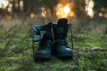 hiker old black boots standing on grass Hard travel concept Nature backgroundの写真素材