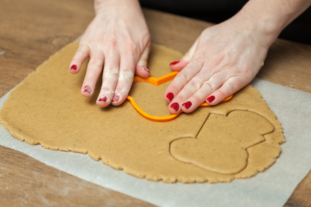 cooking and home concept - close up of female hands making cookies from fresh dough at homeの写真素材