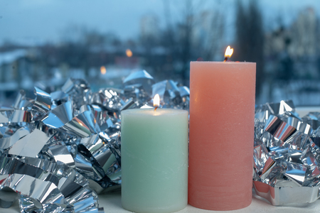 winter decor on windowsill with two candle and silver foil.の写真素材