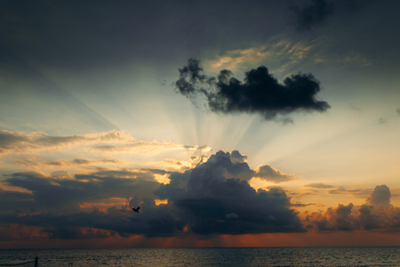 Sunset with clouds, light rays and other atmospheric effect. Dramatic cloudy skyline.の写真素材
