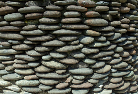 River pebble gravel round stone wall patterned for background. Gray pebbles background for home and home exterior wall and floor decorationの写真素材