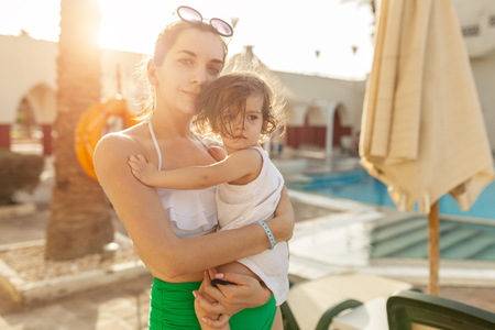 Mother hugging with her little daughter outdoor in nature on sunny day Positive human emotions, feelings, emotions. Portrait of happy family on the vacationの写真素材