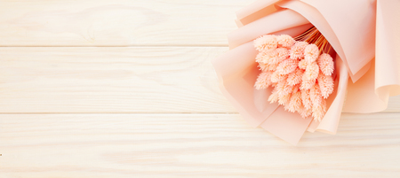 Beautiful bouquet of dry pink flowers on a wooden white background. Minimalism, space for text. Gift Card. abstract spring theme.の写真素材