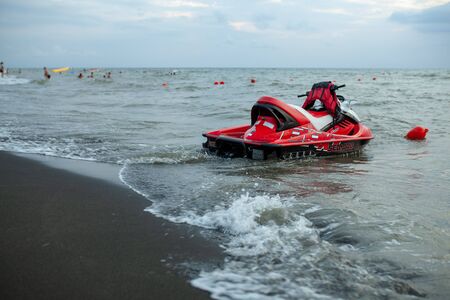 Ureki, Georgia August 2018 Black Sand Beach Red Hydrocycle on the sea water at the bad weather before stormのeditorial素材