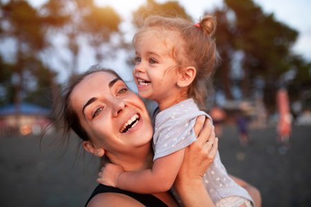 Happy mother and her little daughter outdoor. Mom and daughter enjoying nature together on the black sand beach. Mother Day conceptの写真素材