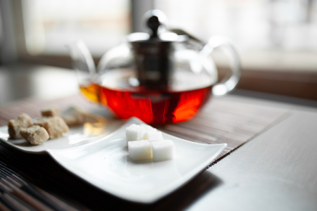 Glass transparent teapot of invigorating fresh aromatic tea on a wooden tableの写真素材