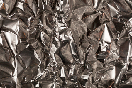 Full frame take of a sheeT of crumpled silver aluminum foil backgroundの写真素材