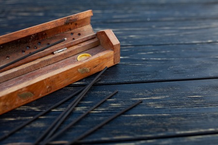 sandalwood sticks on a black wooden table. Traditional Asian culture. Aromatherapy with free space for textの写真素材