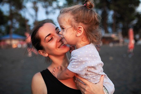 Happy mother and her little daughter outdoor. Mom and daughter enjoying nature together on the black sand beach. Mother Day conceptの写真素材