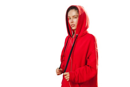 Beautiful caucasian sporty woman to trendy red hoodie on white background in studioの写真素材