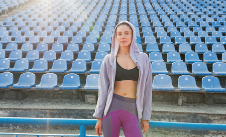 Portrait of a beautiful Caucasian girl athlete on a summer morning jog. A woman is wearing a purple sweatshirt with a hood. Summer Sport Fitness Healthy Lifestyleの写真素材