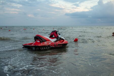 Ureki, Georgia August 2018 Black Sand Beach Red Hydrocycle on the sea water at the bad weather before stormのeditorial素材
